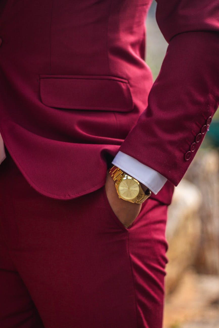 A man wearing a luxury watch and a red suit